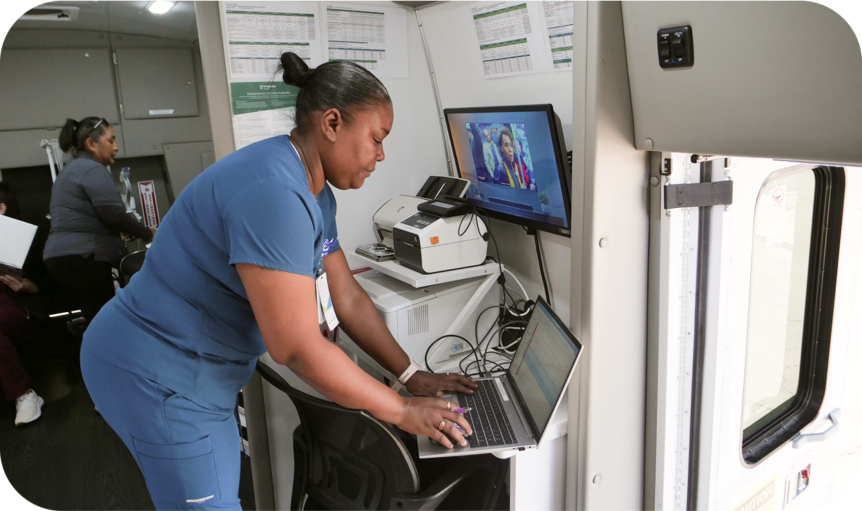 A nurse video chatting with an individual and doing work on a laptop