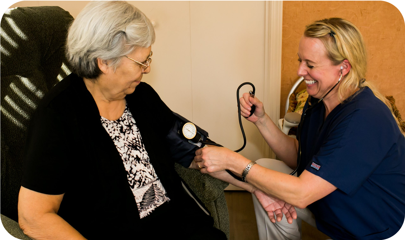 A nurse taking blood pressure of elderly female patient