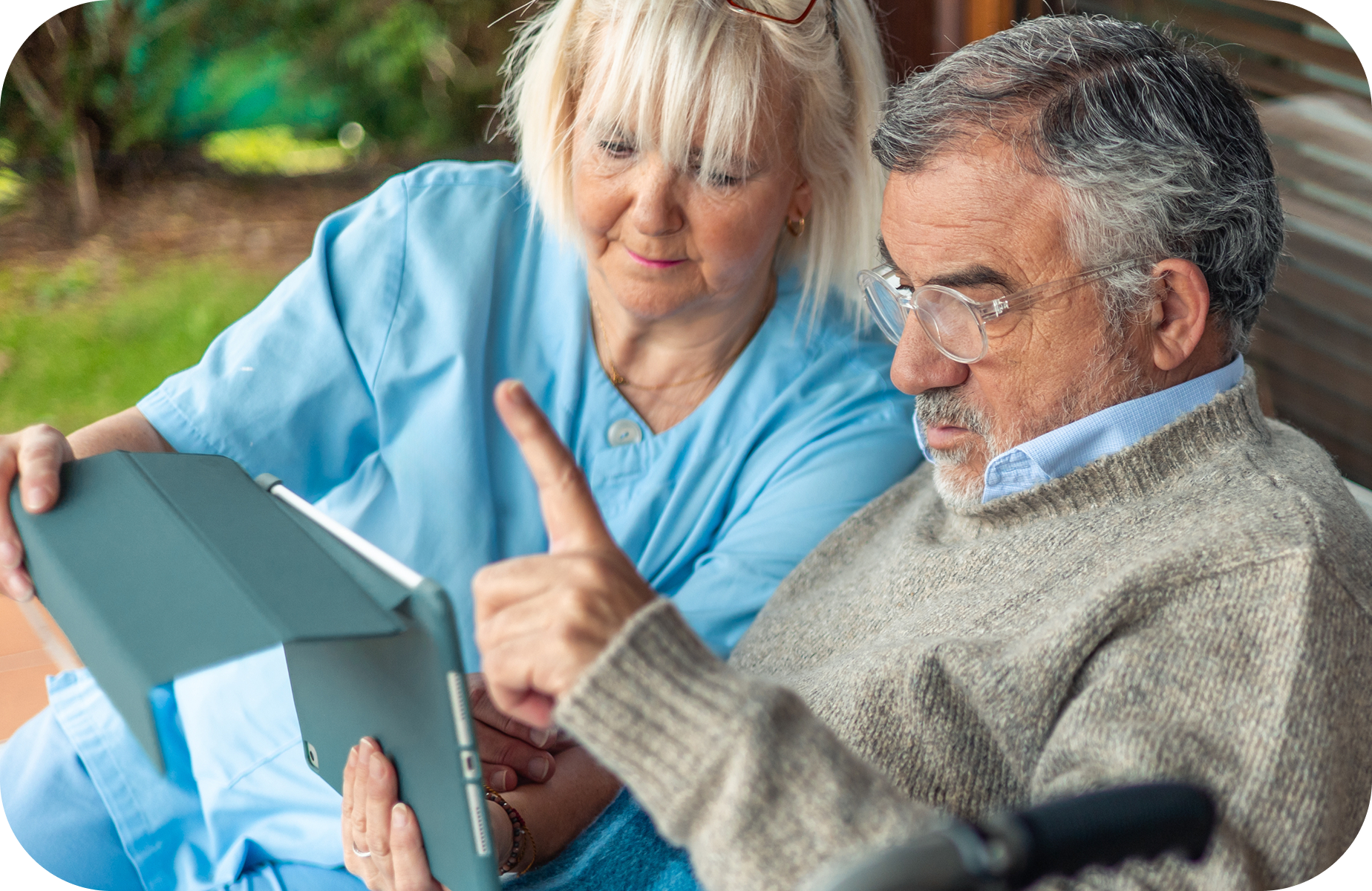 An elderly man and woman viewing a tablet together